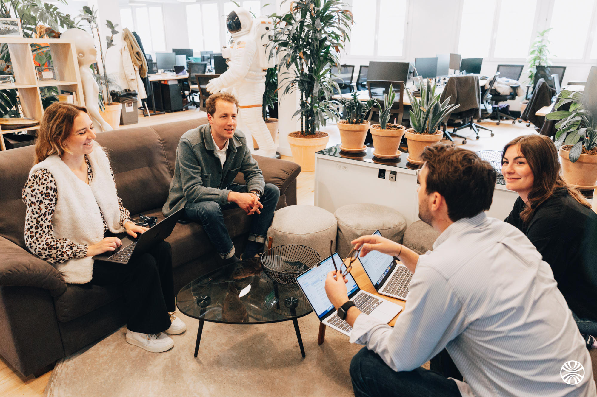 Quatre collaborateurs Mooncard échangeant sur les canapés des bureaux