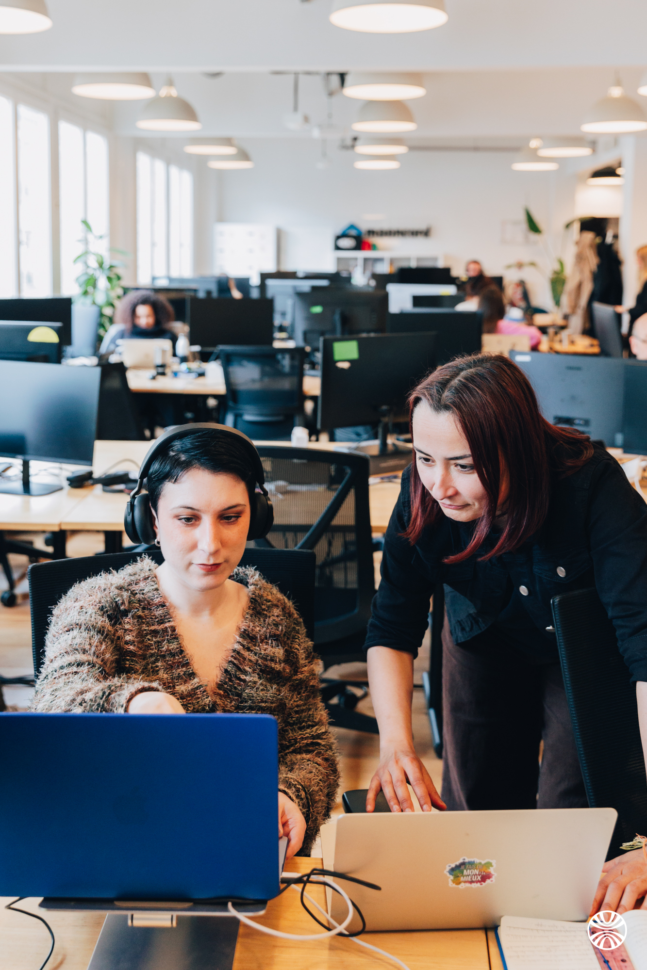 Deux collaboratrices de Mooncard travaillant ensemble à leur poste, dans les bureaux de Paris